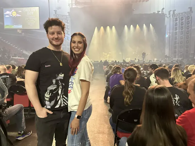 Katie and David at a Fall Out Boy concert, the lit stage behind them